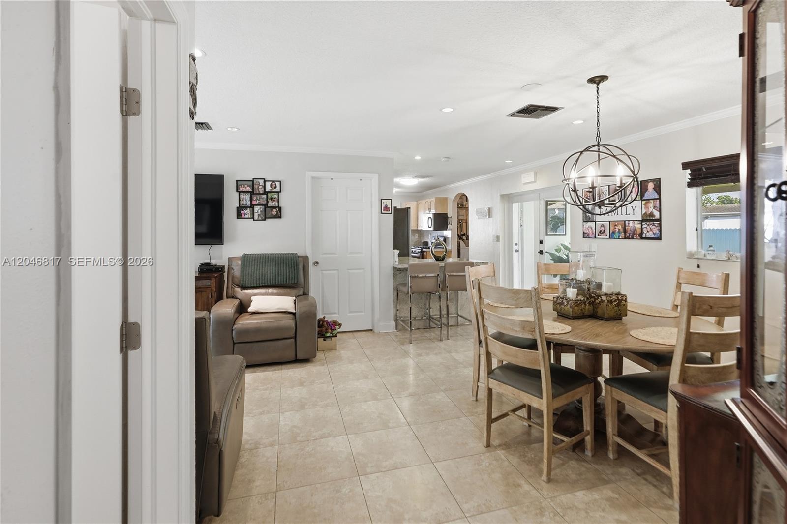 A dining area and living space feature tile flooring, a round table, and neutral walls — 10451 SW 201st Ter, Cutler Bay FL 33189, CUTLER BAY, FL