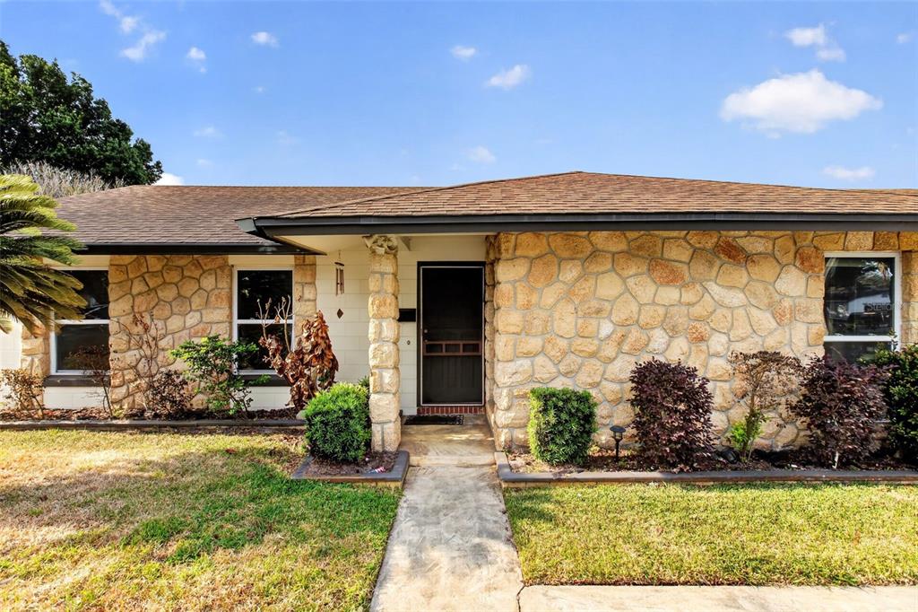 A single-story house features a stone facade, a dark front door, and a concrete walkway — 2738 FIRESIDE COURT, ORLANDO, FL