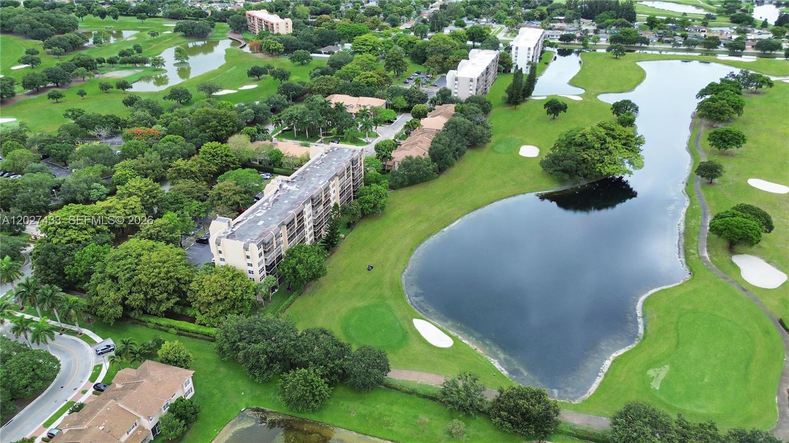 An aerial view shows multi-story apartment buildings situated alongside a golf course and ponds — 3300 W Rolling Hills Cir # 509, Davie FL 33328, DAVIE, FL