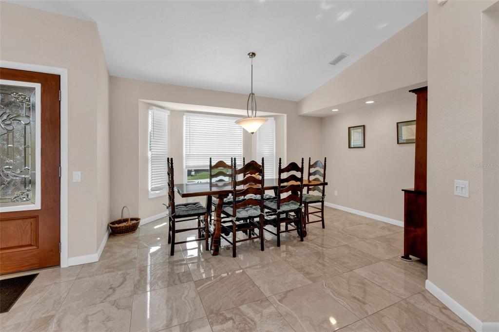 A dining area features tile flooring, a wooden table with six chairs, and a pendant light — 29350 SAM WAY, PUNTA GORDA, FL