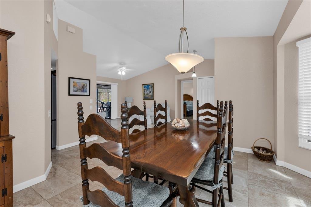 A dining room features a wooden table, spindle-back chairs, and tile flooring — 29350 SAM WAY, PUNTA GORDA, FL