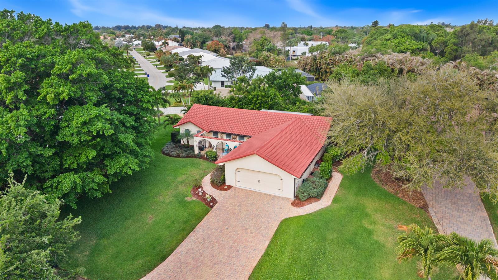An aerial view of a single-story house with a red tile roof and brick driveway — 4176 SE Fairway Court, Stuart FL 34997, STUART, FL