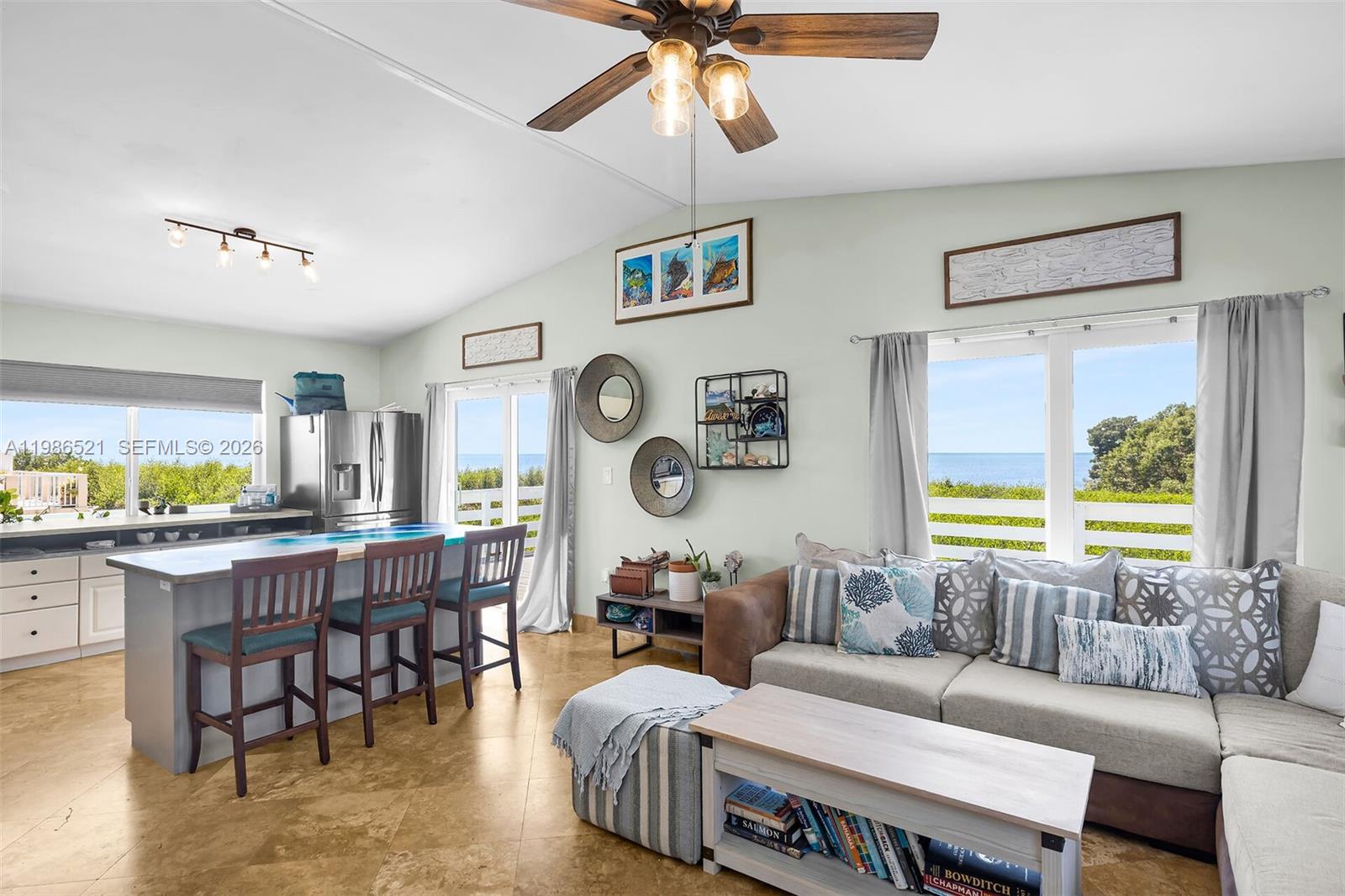 An open-concept living room and kitchen featuring tile floors, a kitchen island, and ocean views — 6501 Oceanview Ave, Marathon FL 33050, MARATHON, FL
