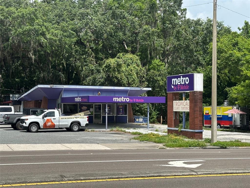 A Metro by T-Mobile storefront with a parking lot and a sign for Tropical Glass Tinting — 706/720 NW 13TH STREET, GAINESVILLE, FL