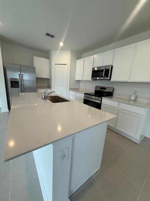 A kitchen features white cabinets, stainless steel appliances, and a large quartz-topped island — 3634 HARDMAN DRIVE, LAKE WALES, FL