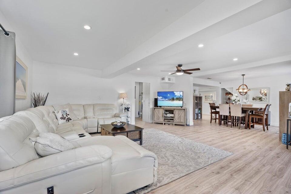 A bright, open-concept living and dining area features white walls, light wood flooring, and furniture — 301 20th Avenue SW, Vero Beach FL 32962, VERO BEACH, FL