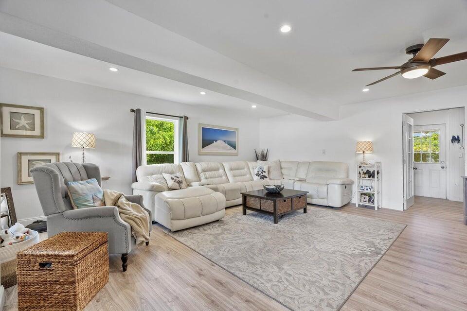 A living room features a white sectional sofa, a gray armchair, and light wood flooring — 301 20th Avenue SW, Vero Beach FL 32962, VERO BEACH, FL
