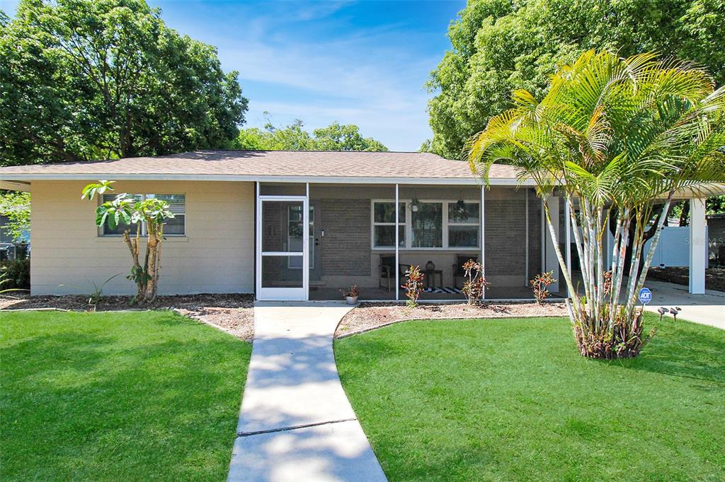 A single-story house with a screened front porch, a concrete walkway, and a palm tree — 2403 19TH AVENUE W, BRADENTON, FL