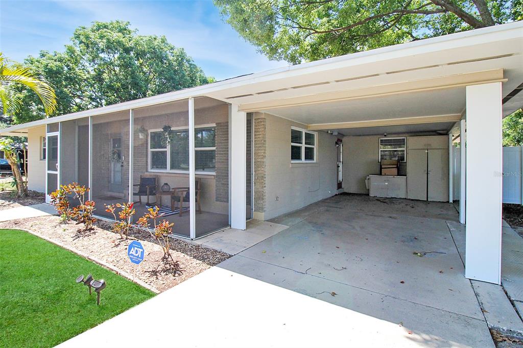 A single-story house exterior features a screened-in porch and an attached carport with concrete flooring — 2403 19TH AVENUE W, BRADENTON, FL