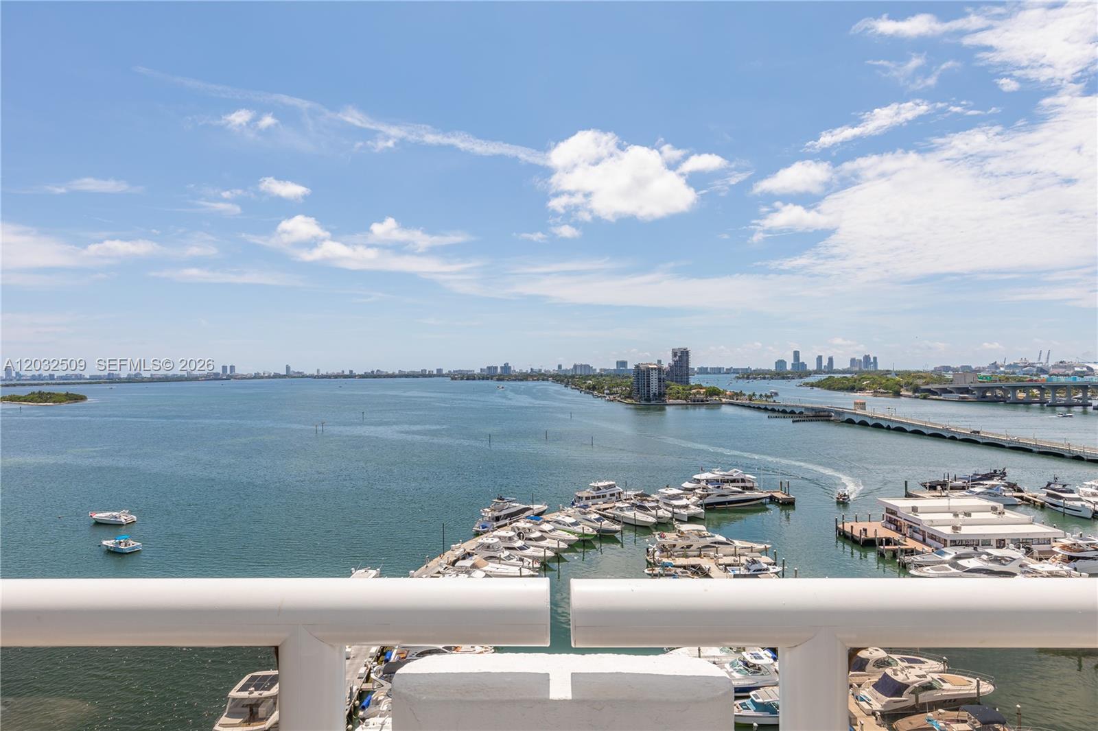 A high-angle view shows a marina with numerous boats and a bridge over water — 1717 N Bayshore Dr # 1533, Miami FL 33132, MIAMI, FL