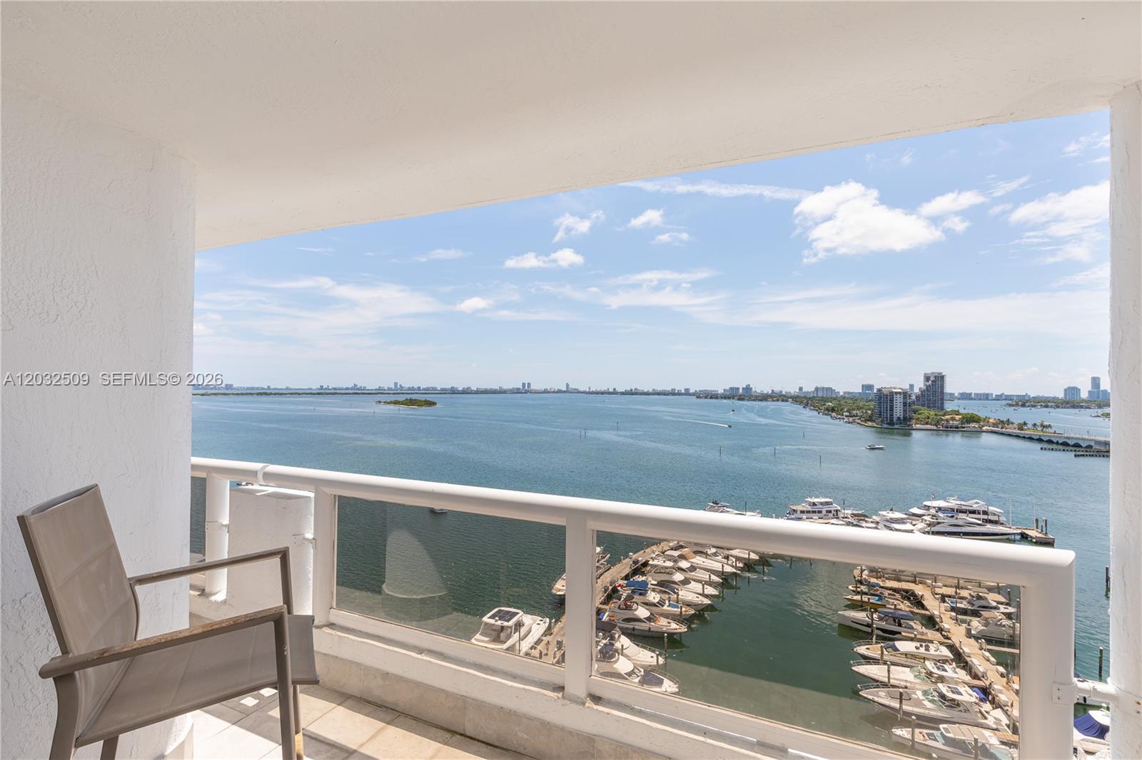 A balcony with a chair overlooks a marina and a large body of water — 1717 N Bayshore Dr # 1533, Miami FL 33132, MIAMI, FL