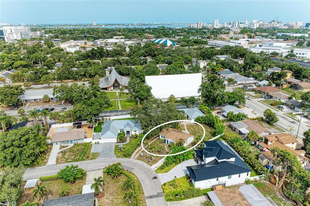 An aerial view shows a single-story house with a brown roof circled in a white oval — 1300 LOMA LINDA COURT, SARASOTA, FL