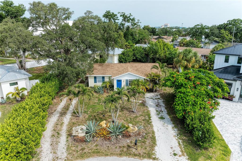 An aerial view of a single-story house with a gravel driveway and tropical landscaping — 1300 LOMA LINDA COURT, SARASOTA, FL