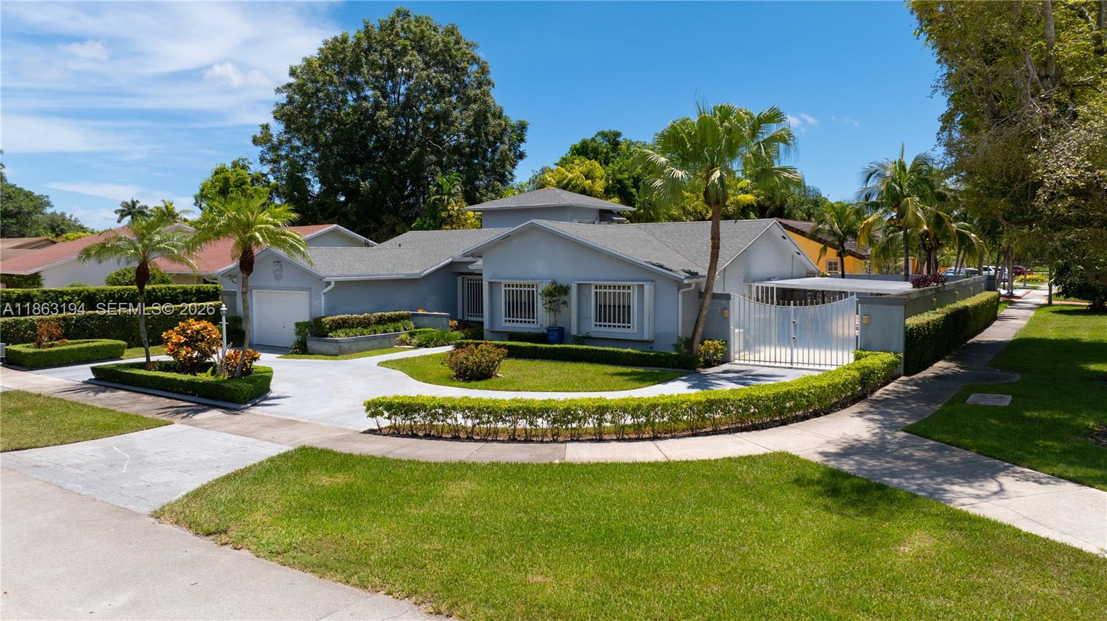 A single-story house with a gray exterior, a circular driveway, and manicured hedges — 11680 SW 92nd St, Miami FL 33176, MIAMI, FL
