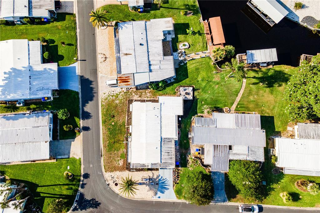 An aerial view shows several mobile homes with metal roofs situated along a paved road — 1004 TODD WAY, TAVARES, FL