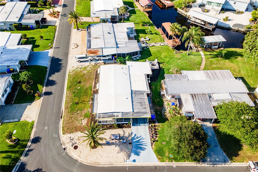 An aerial view shows several mobile homes with metal roofs situated along a paved street — 1004 TODD WAY, TAVARES, FL