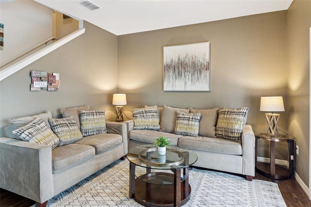 A living room features two beige sofas, a glass coffee table, and two side lamps — 3222 CUPID PLACE, KISSIMMEE, FL