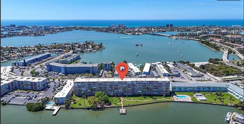 An aerial view shows a multi-story apartment complex situated along a waterfront bay — 1847 SHORE DRIVE S UNIT 710, SOUTH PASADENA, FL
