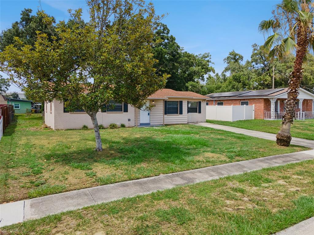 A single-story house with a light-colored exterior, a front lawn, and a palm tree — 712 CLAYTON STREET, BRANDON, FL