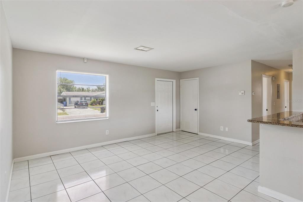 A room with white tiled floors, light gray walls, a window, and two white doors — 712 CLAYTON STREET, BRANDON, FL