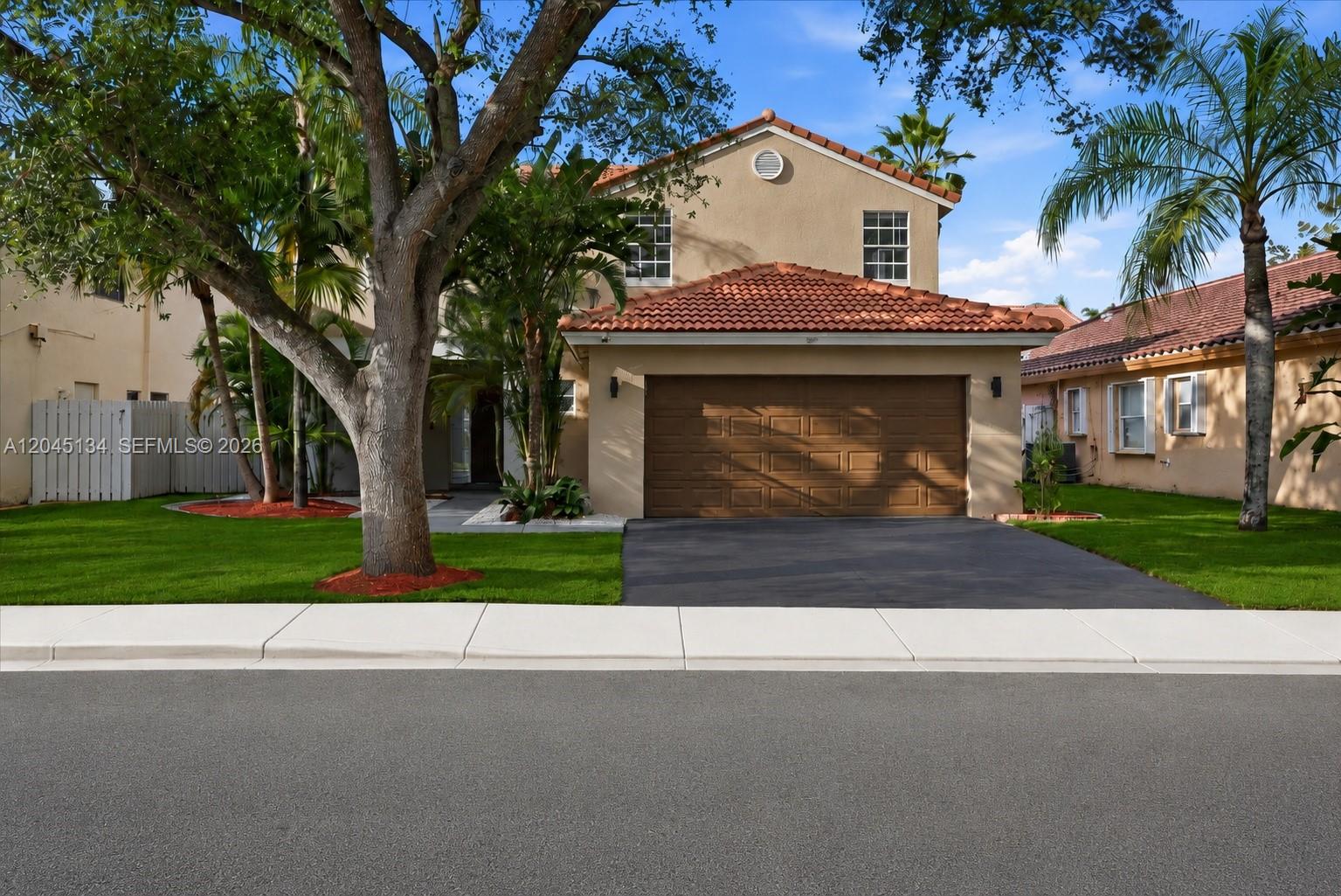 A two-story tan house with a brown garage door and a red tile roof — 13209 NW 12th Ct, Sunrise FL 33323, SUNRISE, FL