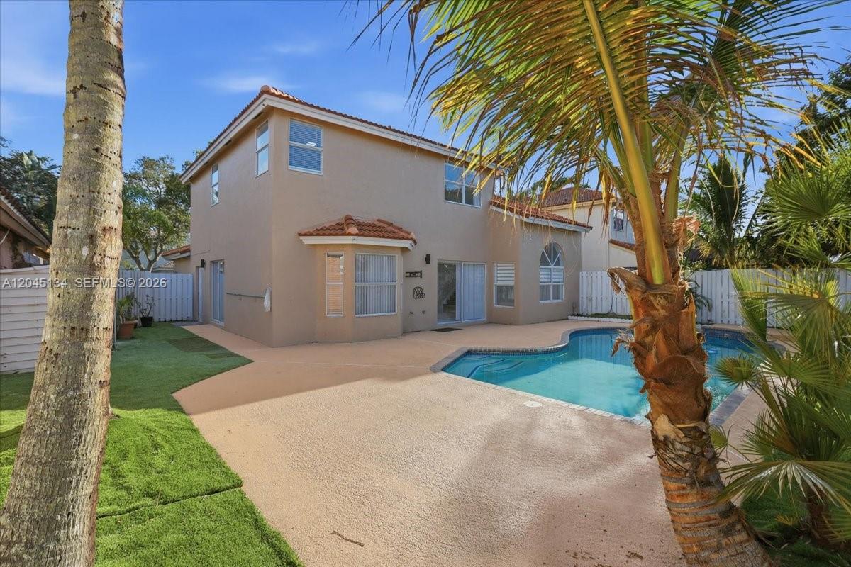 A two-story house exterior features a swimming pool, patio, and palm trees — 13209 NW 12th Ct, Sunrise FL 33323, SUNRISE, FL