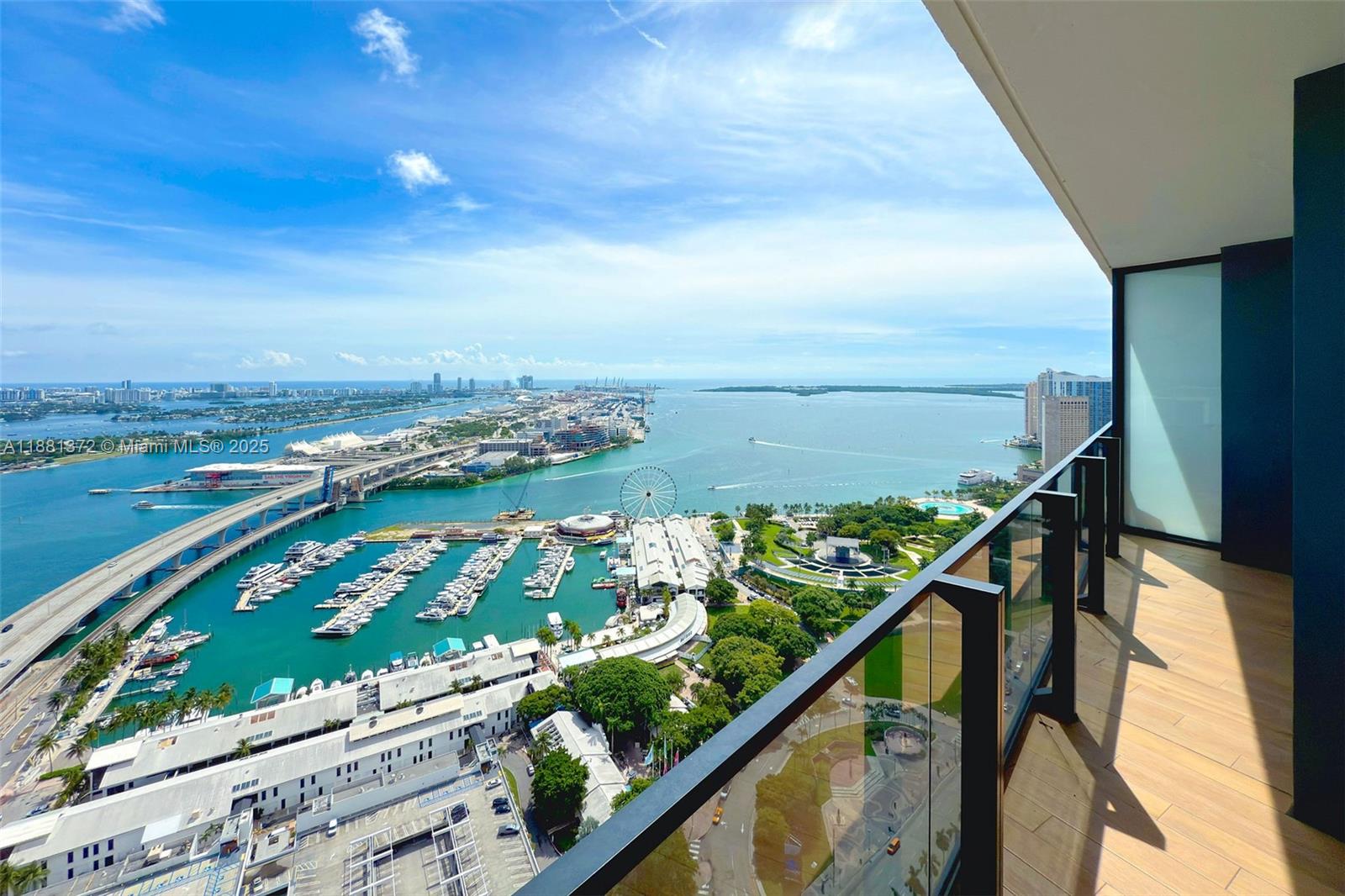 A high-angle view from a balcony overlooking a marina, a bridge, and the ocean — 398 NE 5th St # 3810, Miami FL 33132, MIAMI, FL