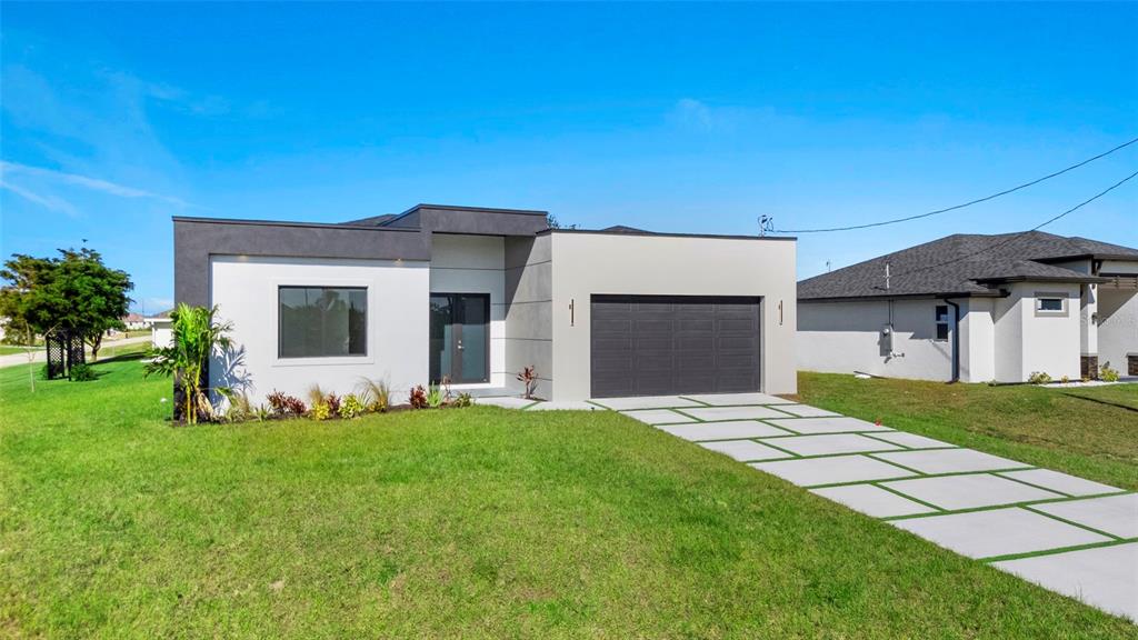 A modern entryway features double glass doors set in a white wall with horizontal grooves — 2725 EMBERS PARKWAY W, CAPE CORAL, FL