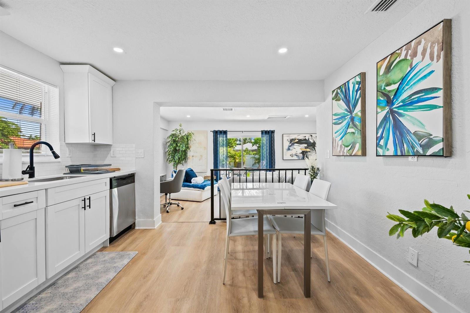 A kitchen with white cabinets and a dining area overlooking a living space — 415 SE 3rd Avenue, Delray Beach FL 33483, DELRAY BEACH, FL