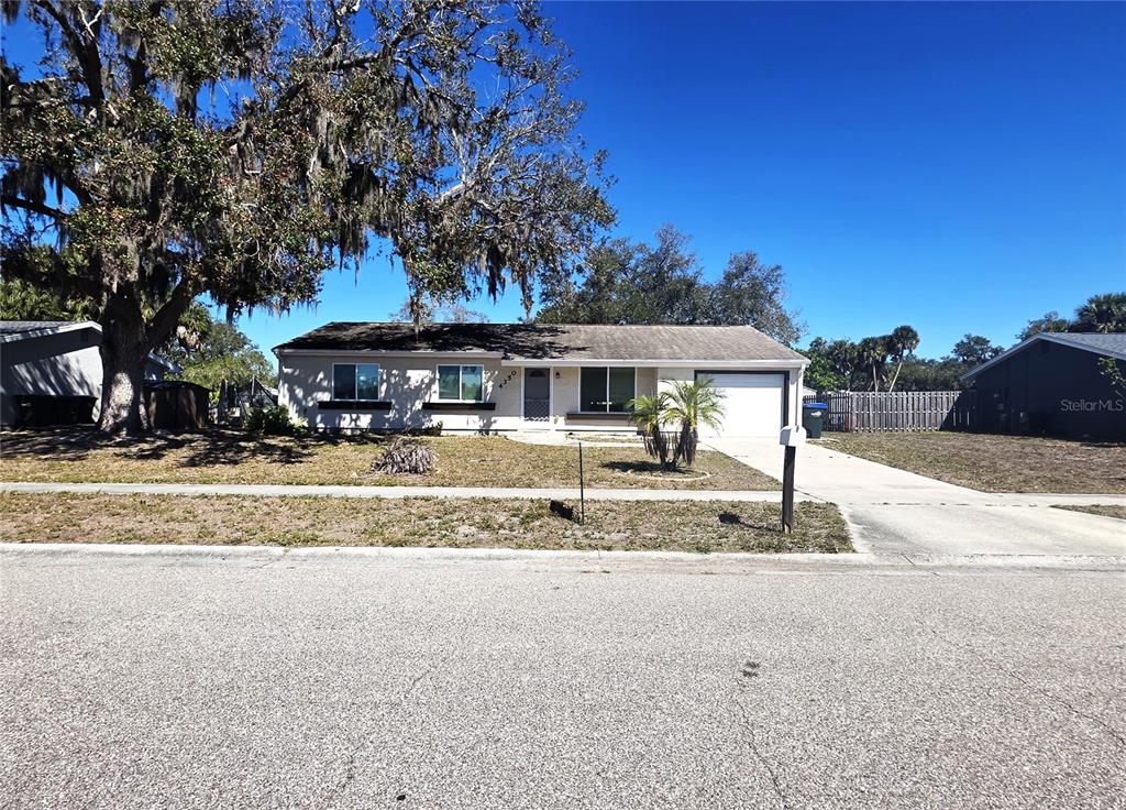 A single-story house with a light-colored exterior, a garage, and a large tree in front — 4350 MARALDO AVENUE, NORTH PORT, FL