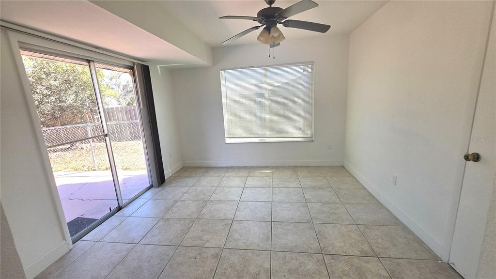 A dining room with tile flooring, a ceiling fan, a window, and sliding glass doors — 4350 MARALDO AVENUE, NORTH PORT, FL