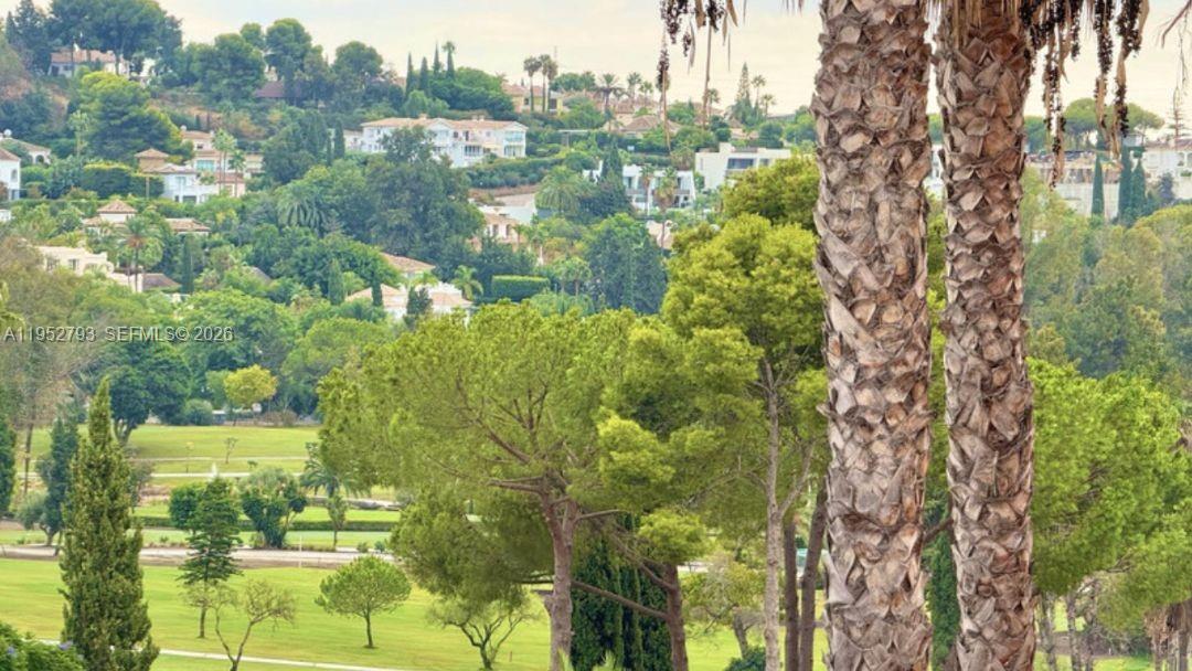 A view of a green golf course with houses nestled in the hills beyond — 29679 C. Chopo Marbella-Spain # 7311, FL, FL