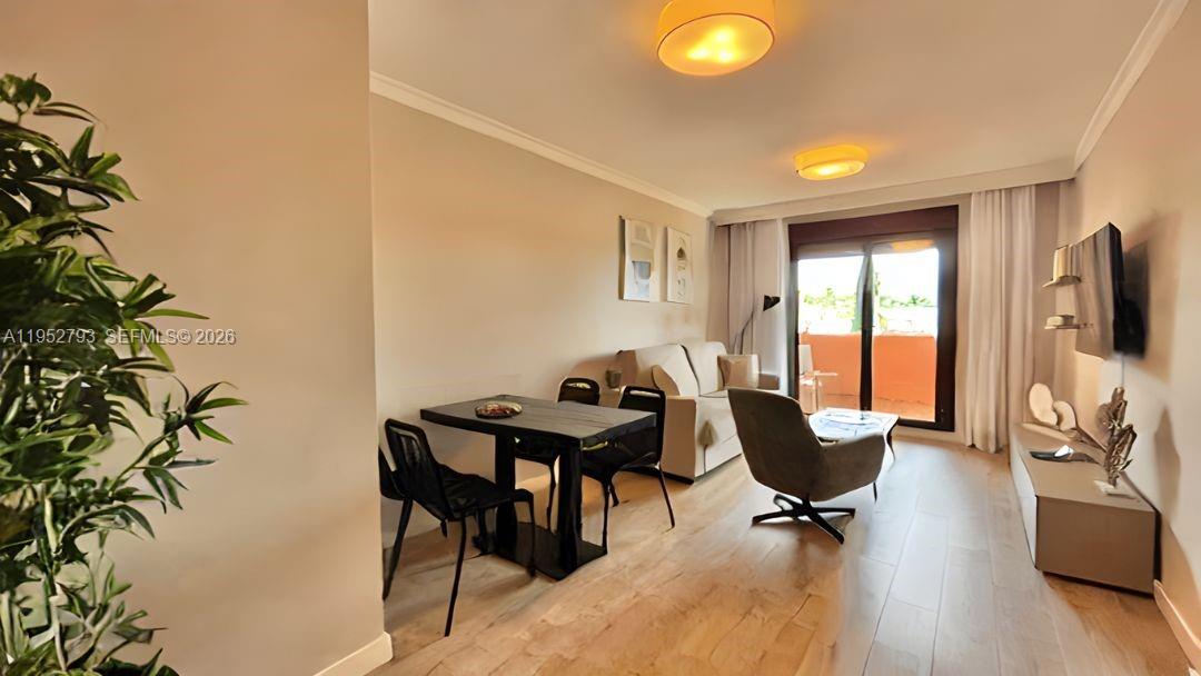 A living and dining area features light wood flooring, modern furniture, and a sliding glass door — 29679 C. Chopo Marbella-Spain # 7311, FL, FL