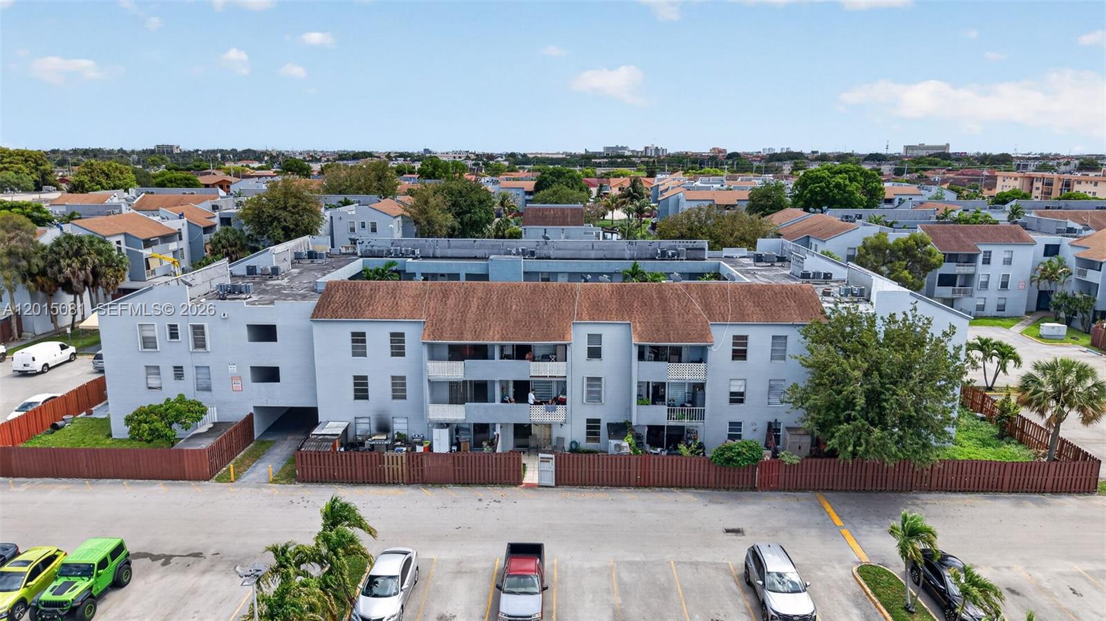 An aerial view of a multi-story apartment building with a brown roof and parking lot — 1755 W 60th St # D301, Hialeah FL 33012, HIALEAH, FL