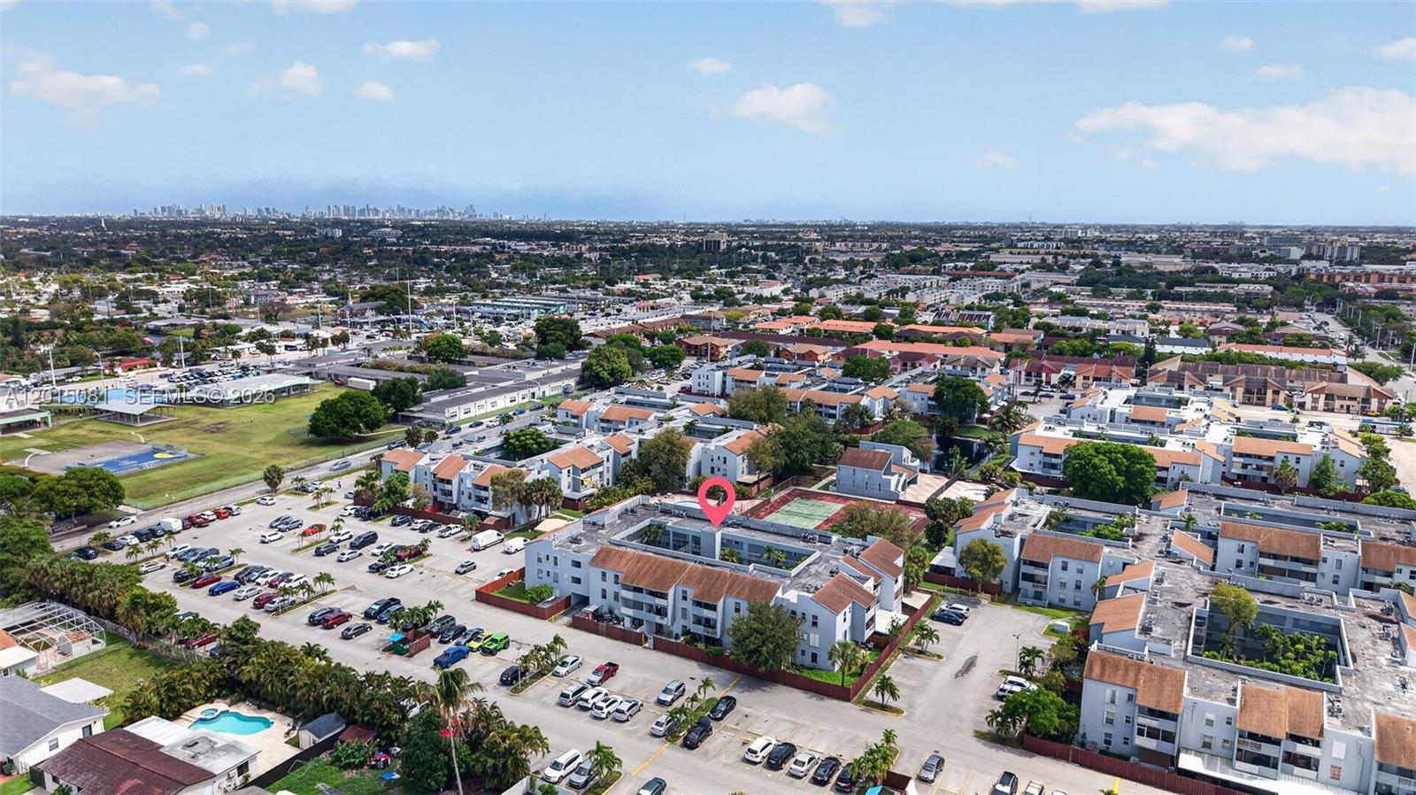An aerial view shows a multi-story apartment complex with a central courtyard and parking lot — 1755 W 60th St # D301, Hialeah FL 33012, HIALEAH, FL