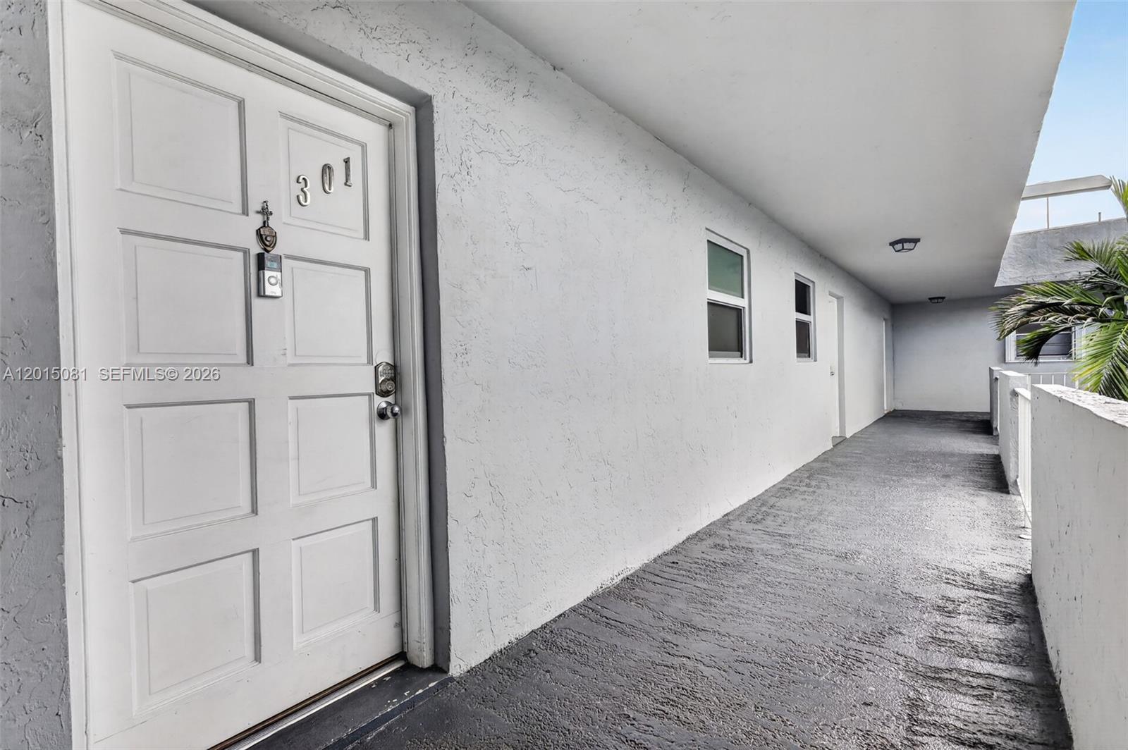A white door marked 301 opens onto a gray concrete outdoor walkway — 1755 W 60th St # D301, Hialeah FL 33012, HIALEAH, FL