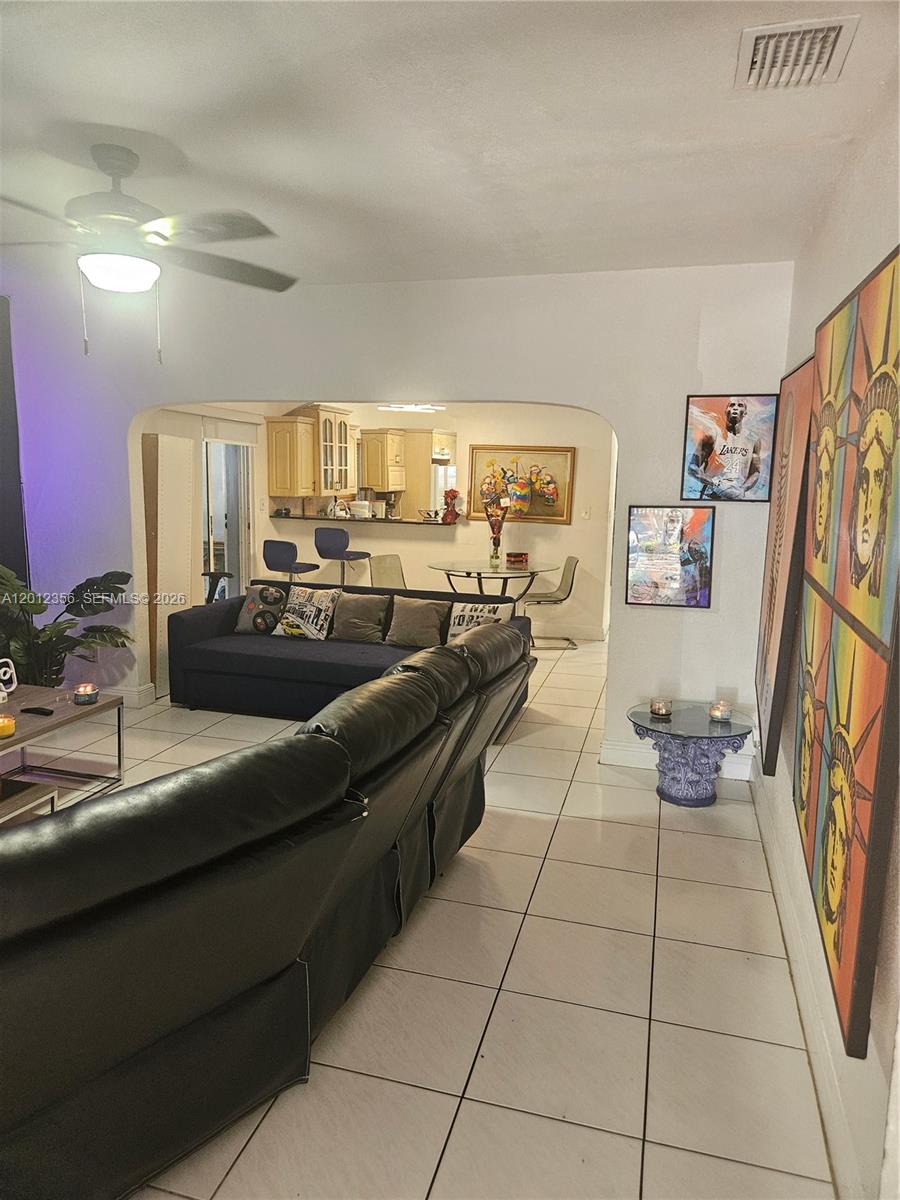 A living room with tile floors leads into an open kitchen and dining area — 2231 NW 4th Ter, Miami FL 33125, MIAMI, FL