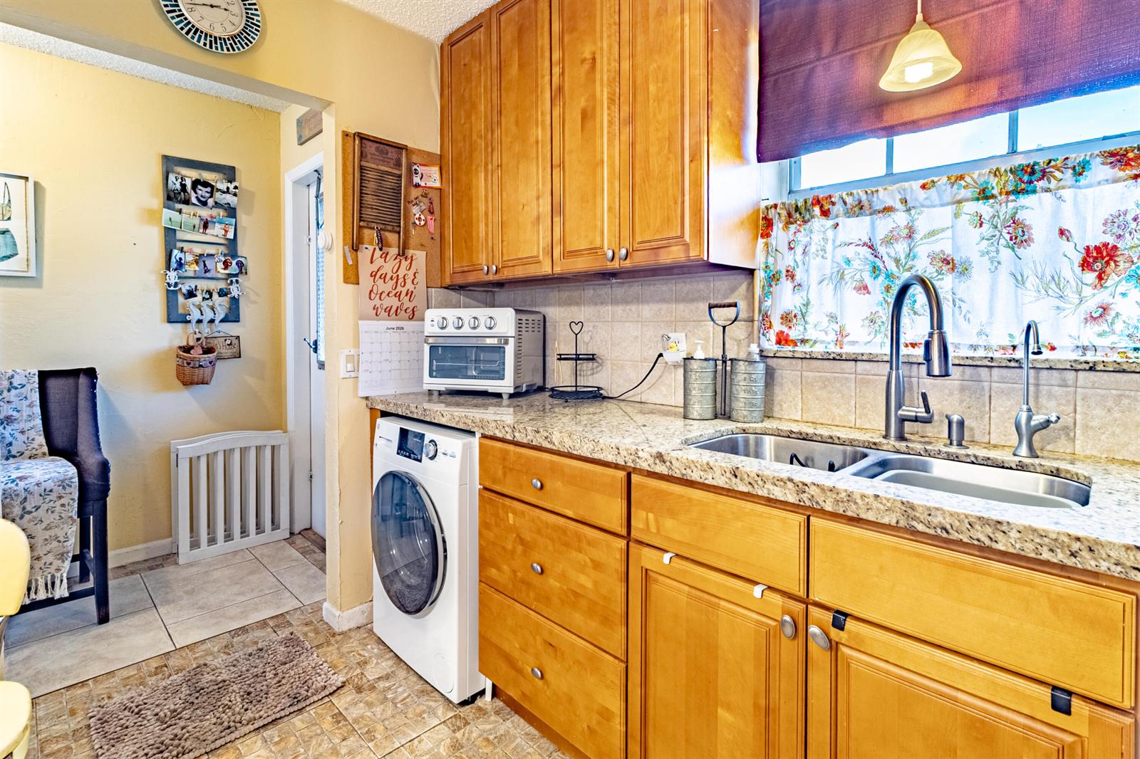 A kitchen features wooden cabinets, granite countertops, a stainless steel sink, and a built-in washer — 849 Salem Lane, Lake Worth FL 33467, LAKE WORTH, FL