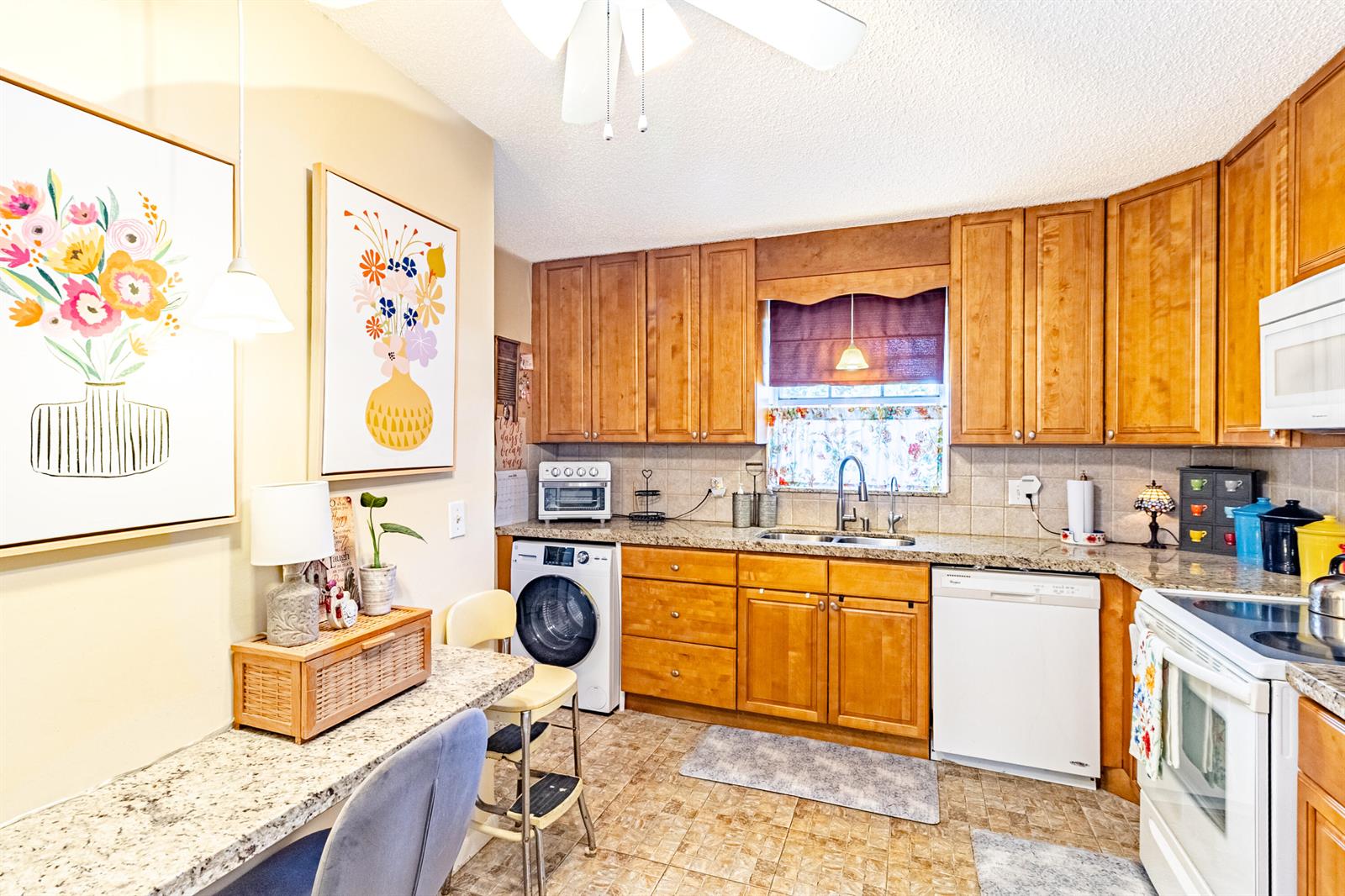 A kitchen features wood cabinets, granite countertops, a built-in washer, and a breakfast bar area — 849 Salem Lane, Lake Worth FL 33467, LAKE WORTH, FL