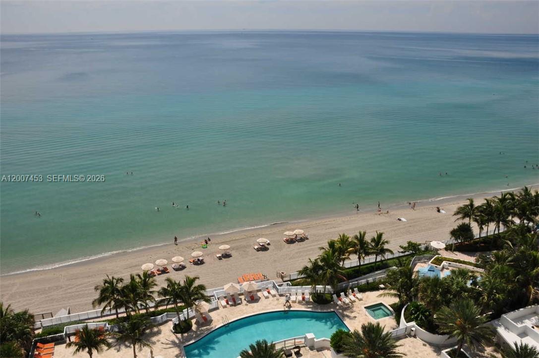 An aerial view shows a swimming pool, beach chairs, and the ocean — 3535 S OCEAN DR # 2002, Hollywood FL 33019, HOLLYWOOD, FL