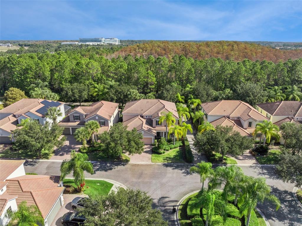 An aerial view shows a row of suburban houses with tile roofs and landscaped yards — 7991 ESTA LANE, ORLANDO, FL
