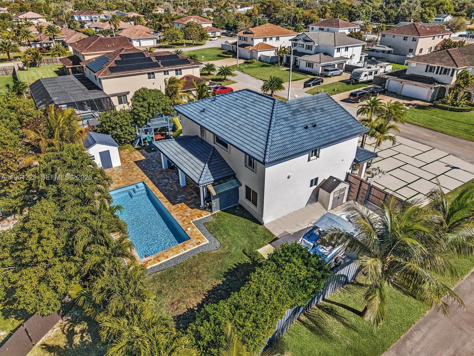 An aerial view shows a two-story house with a blue roof, pool, and boat storage — 22690 SW 127th Ct, Miami FL 33170, MIAMI, FL