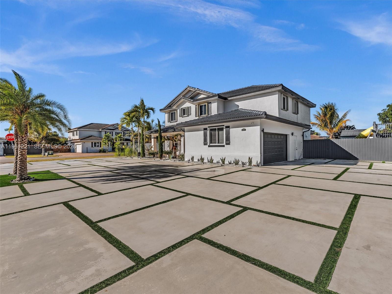 A two-story house with a large concrete paver driveway featuring grass strips between the slabs — 22690 SW 127th Ct, Miami FL 33170, MIAMI, FL