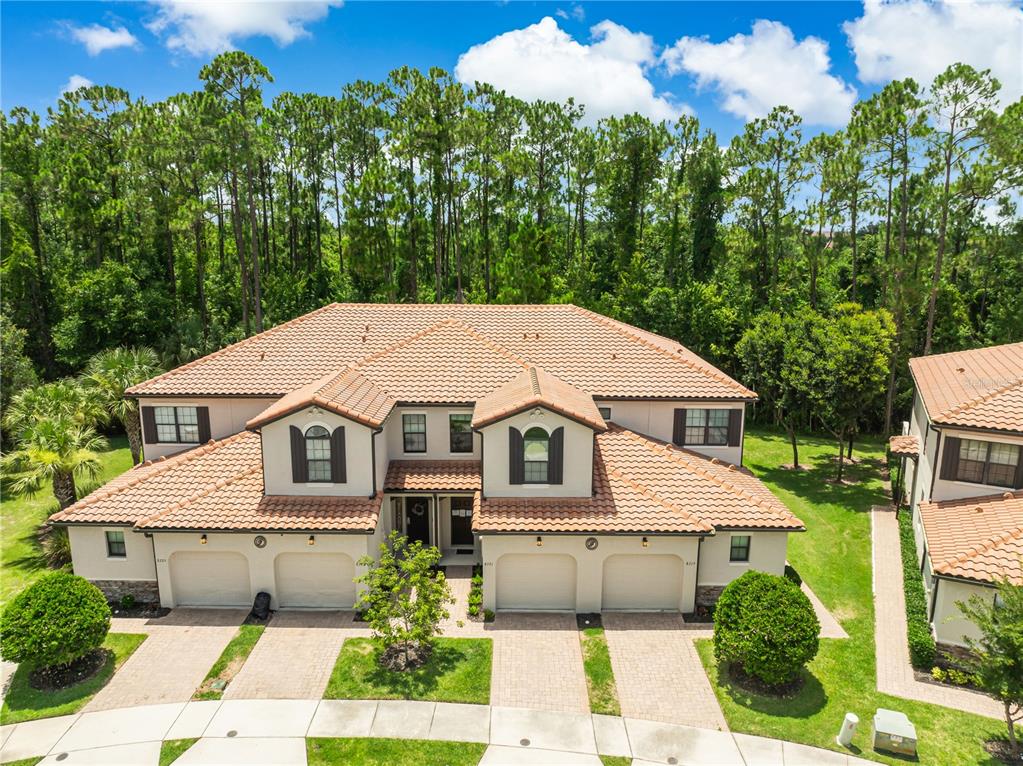 An aerial view of a two-story duplex with a tile roof and four garage doors — 8221 ROSEVILLE ROAD, DAVENPORT, FL