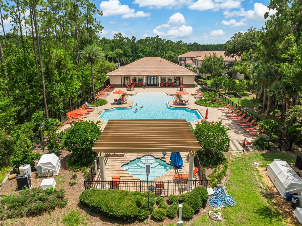 An aerial view of a community swimming pool and hot tub with surrounding lounge chairs — 8221 ROSEVILLE ROAD, DAVENPORT, FL