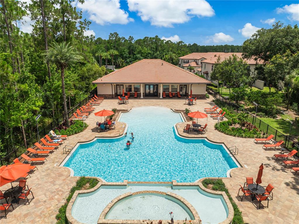 An aerial view of a swimming pool with lounge chairs and a clubhouse building — 8221 ROSEVILLE ROAD, DAVENPORT, FL