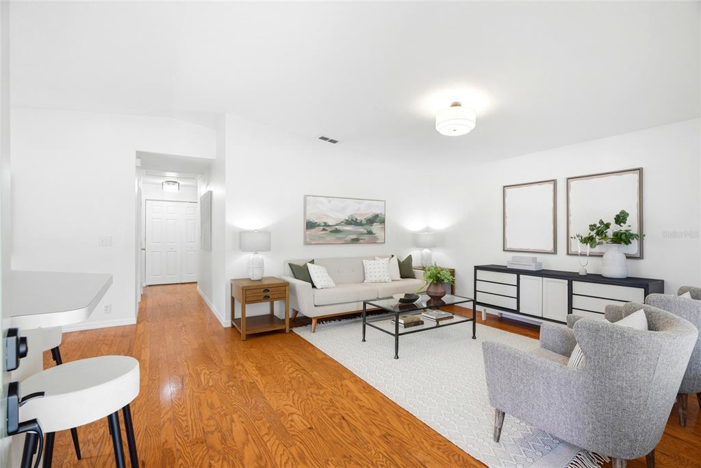 A living room features hardwood floors, a beige sofa, two gray armchairs, and a sideboard — 608 9TH AVENUE N, ST PETERSBURG, FL