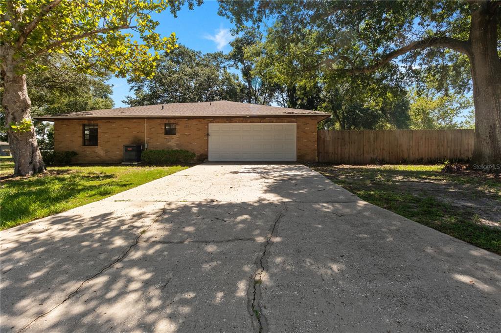 A brick house with a two-car garage and a cracked concrete driveway — 2417 ROSLYN LANE, LAKELAND, FL