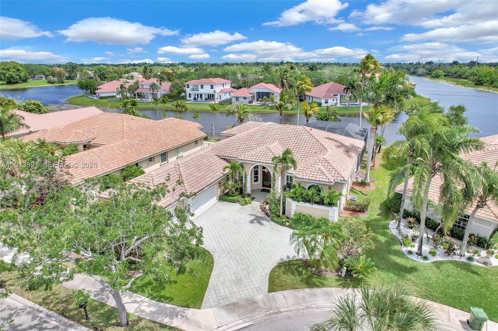 An aerial view shows a single-story house with a tile roof and a paved driveway — 2715 Edgewater Court, Weston FL 33332, WESTON, FL