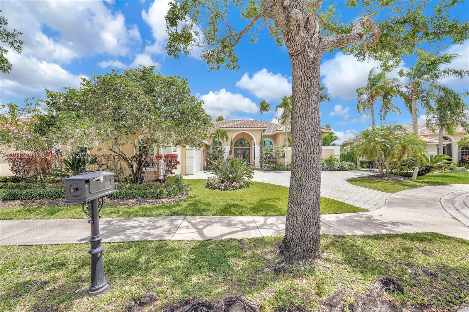 A single-story house with a paved driveway, a large tree, and a mailbox in front — 2715 Edgewater Court, Weston FL 33332, WESTON, FL